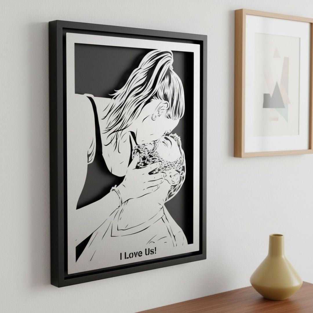 Custom metal portrait of a mother kissing her baby, silver steel in a black frame with a short line of text below