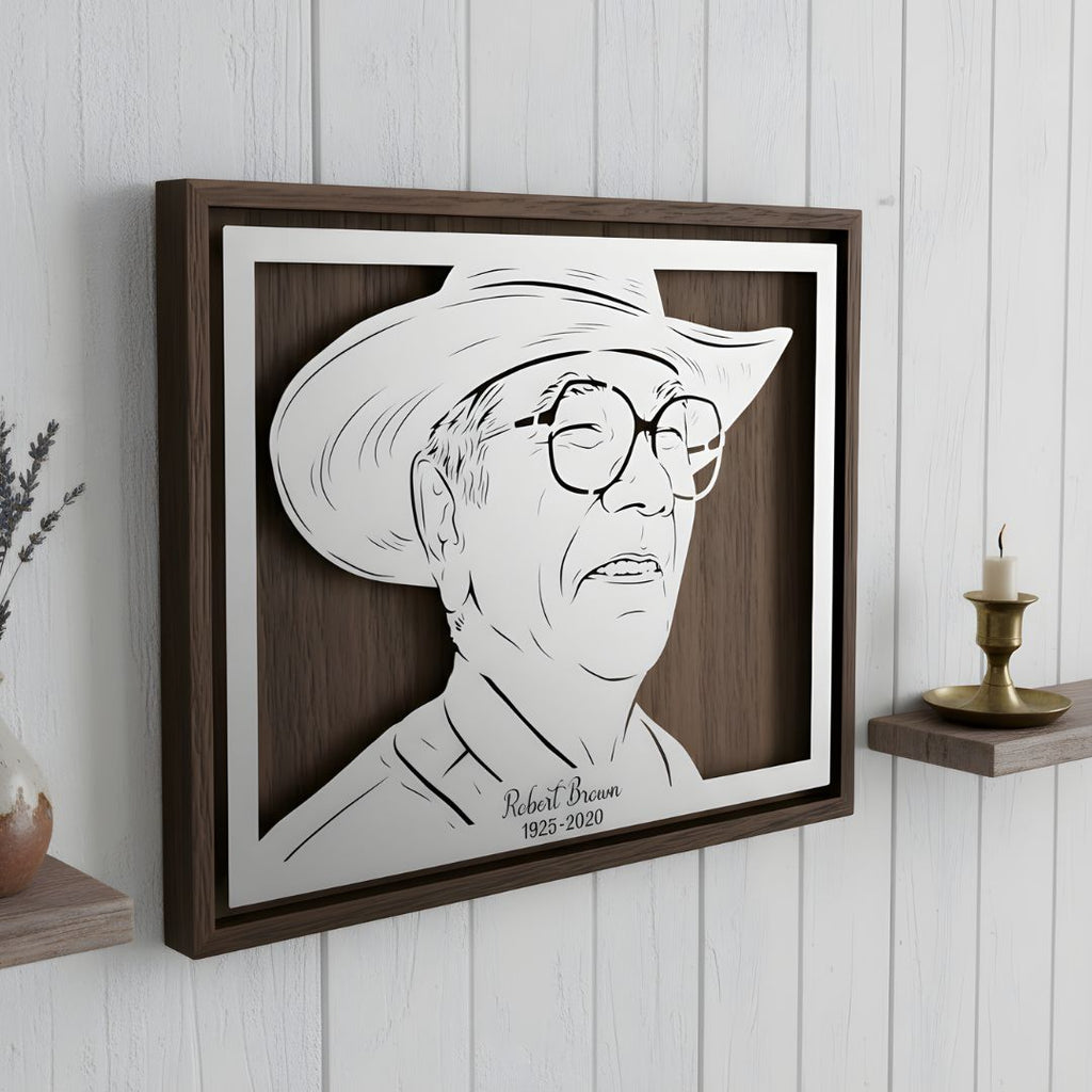 Memorial portrait of a man in a cowboy hat and glasses, landscape steel in a walnut frame with his name and years below