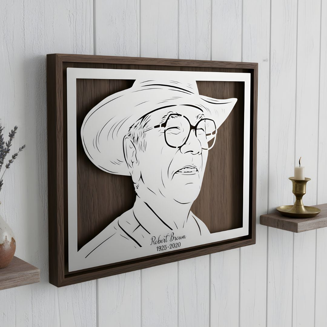 Memorial portrait of a man in a cowboy hat and glasses, landscape steel in a walnut frame with his name and years below