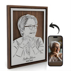 Framed memorial portrait of a smiling grandmother, steel in a walnut frame with her name and years below, next to the photo it was drawn from